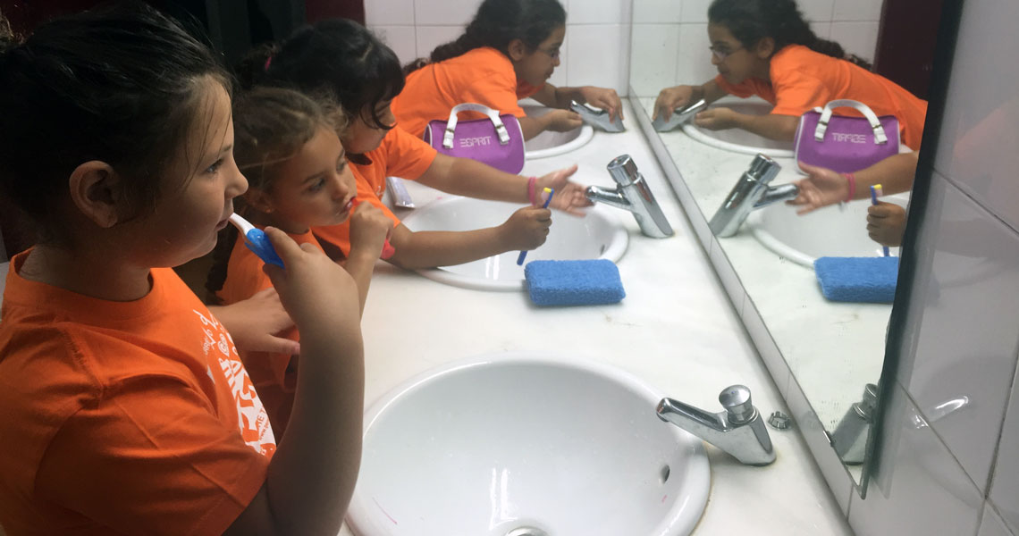 Nenes de colònies rentant-se les dents