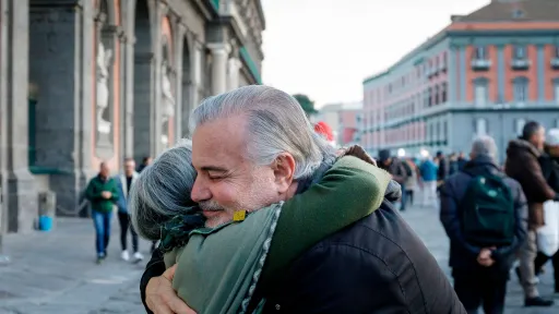 Dues persones grans fent-se una abraçada en un carrer