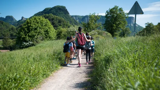 Infants acompanyats d'una monitora d'excursió pel camp