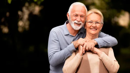 Parella de persones grans abraçades i somrients