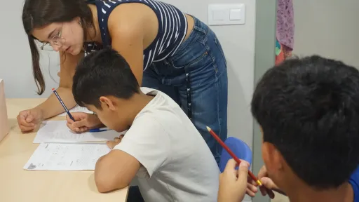 Educadora estudiants amb infants al centre socioeducatiu Poble-sec