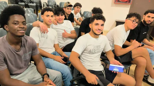 Joves migrats asseguts a un saló d'actes