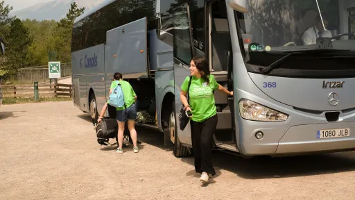 Monitores de colònies d'estiu baixant d'un autocar