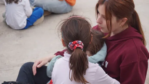 Nena amb monitora al pati de centre socioeducatiu Poblenou