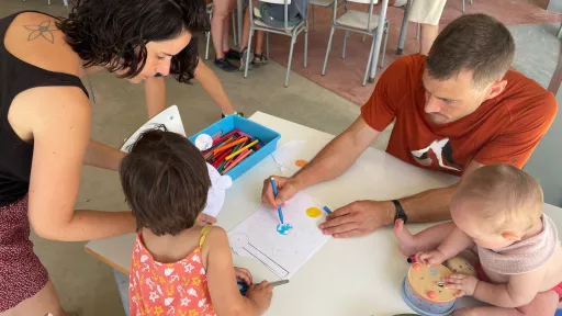 Pare, mare, infant i bebé dibuixant a un aula d'Artur Martorell