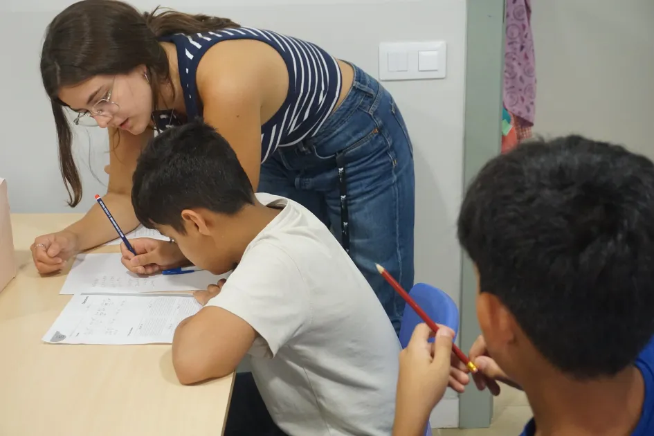 Educadora estudiants amb infants al centre socioeducatiu Poble-sec