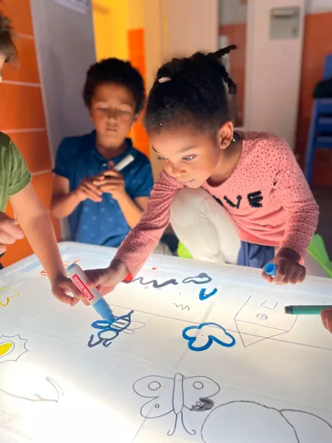 Infants dibuixant a un aula d'un centre socioeducatiu