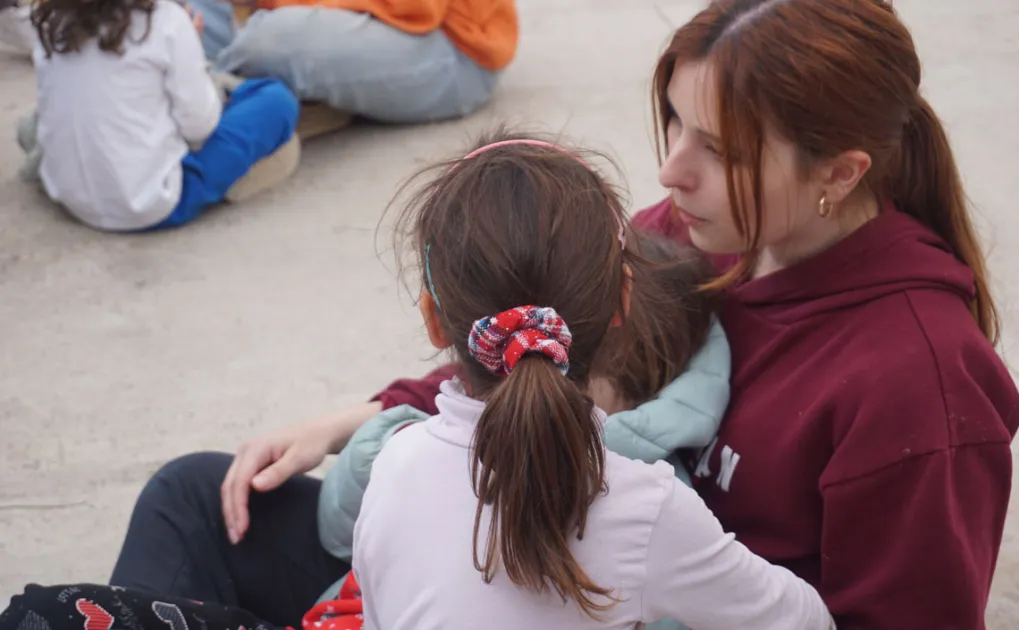 Nena amb monitora al pati de centre socioeducatiu Poblenou