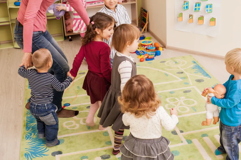 Professora amb bebes jugant a una escola infantil