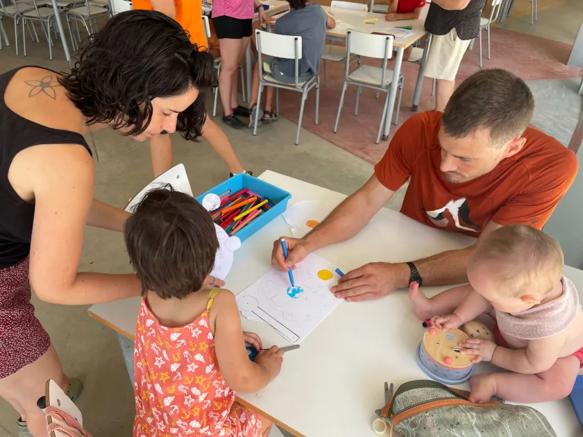 Pare, mare, infant i bebé dibuixant a un aula d'Artur Martorell