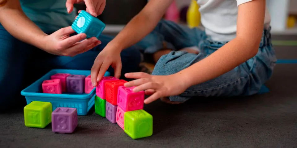 Infant i adult jugant amb un puzzle de colors vius