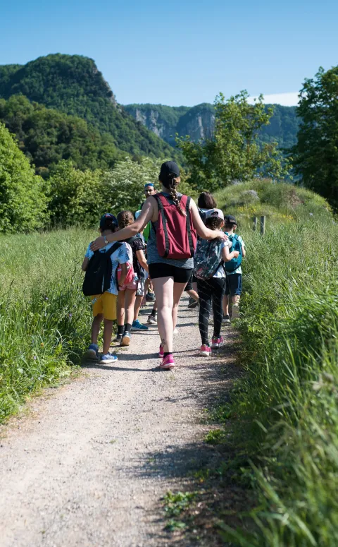 Infants acompanyats d'una monitora d'excursió pel camp