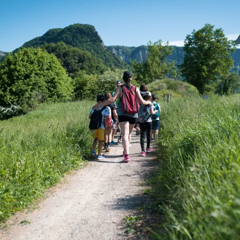Infants acompanyats d'una monitora d'excursió pel camp