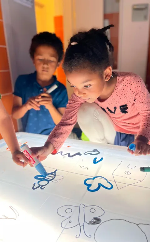 Infants dibuixant a un aula d'un centre socioeducatiu
