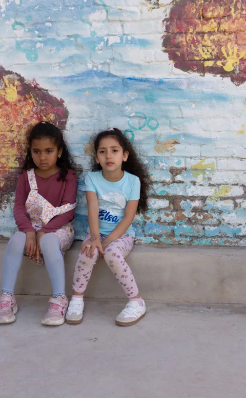 Infants davant un mural d'un mapamundi al centre socioeducatiu Poblenou